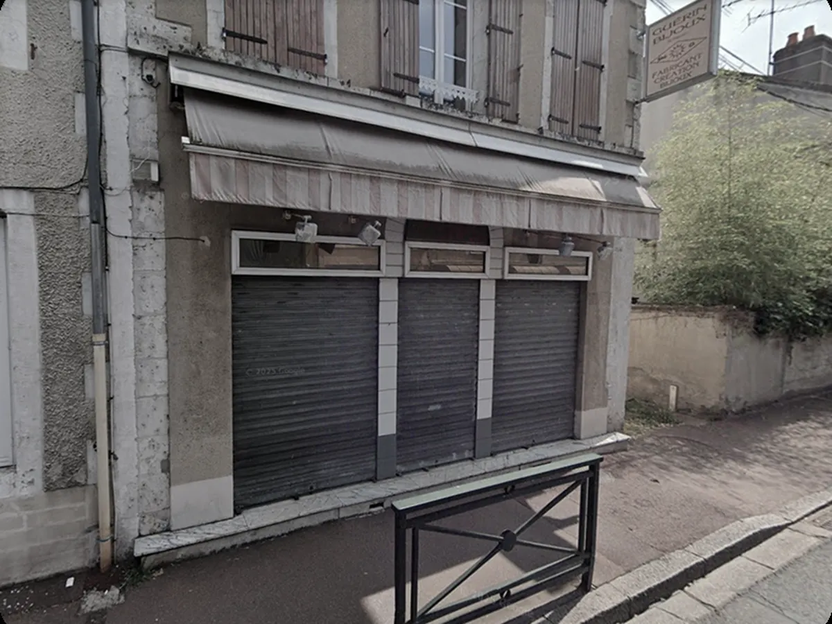 Ancienne devanture du local, rideaux metalliques baisses et store defraichi, avant intervention
