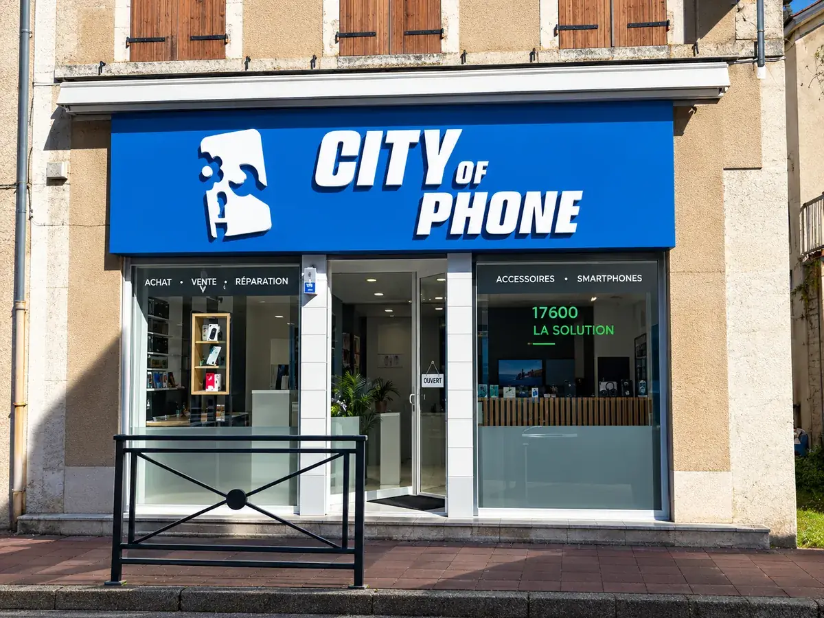 Nouvelle devanture City of Phone avec enseigne bleue et lettrage de vitrine, boutique ouverte